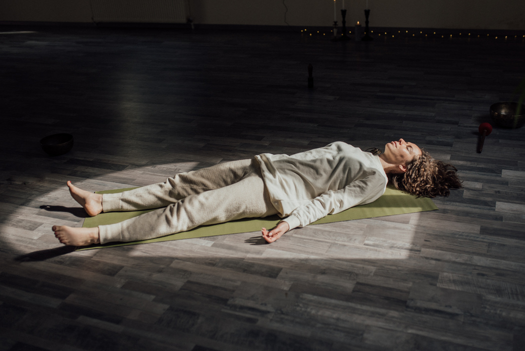 Woman Lying Down on Floor Relaxing and Meditating