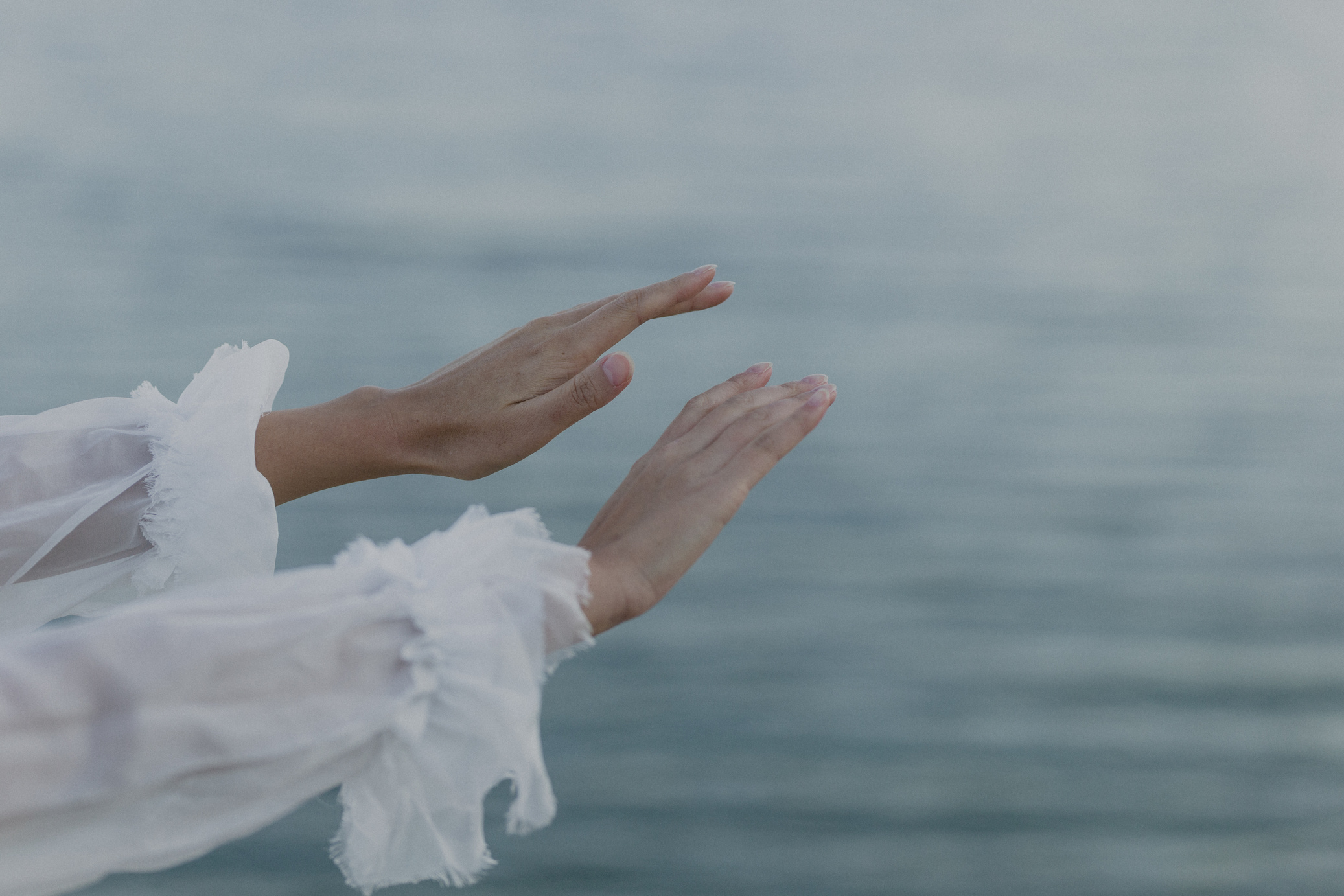 Hands Stretched Out with Calm Beach Background